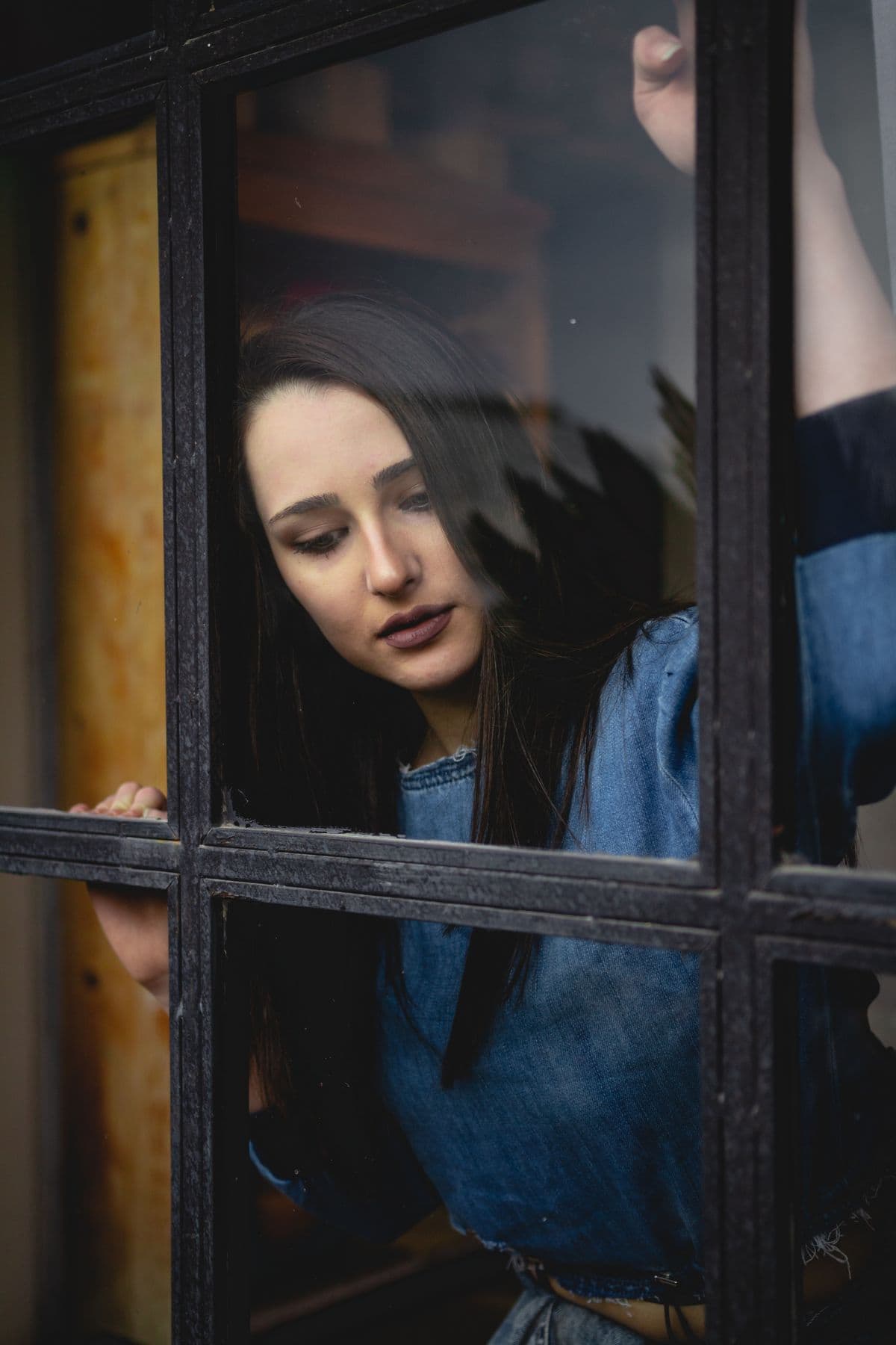 A woman looking thoughtfully through a window